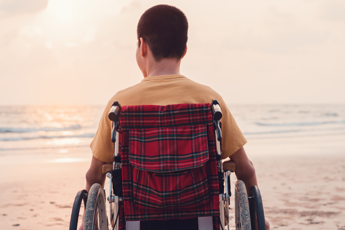 enfant en fauteuil roulant qui observe la mer