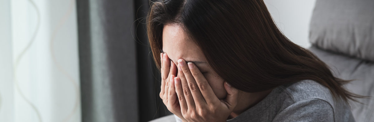 Femme la tête dans les mains victime de stress post-traumatique